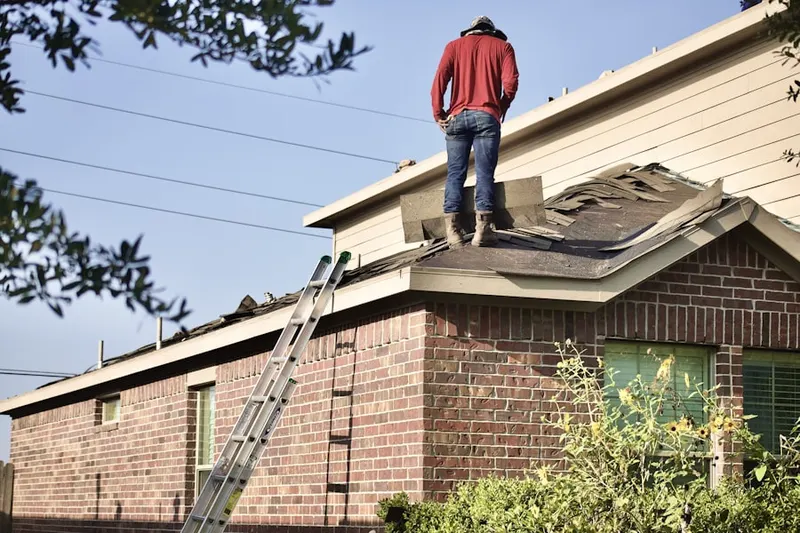 Professional roofer working on a residential roof in Kingston